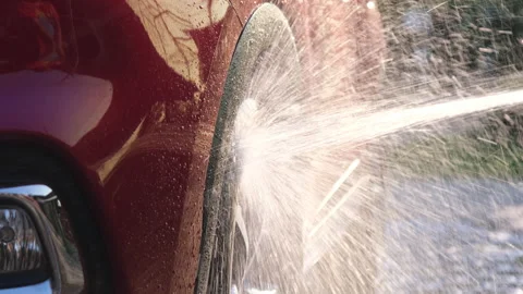 A worker is using a high-pressure cleaner to wash the car. Stock Footage 188433109