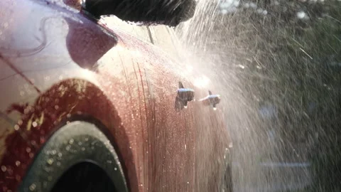 A worker is using a high-pressure cleaner to wash the car. Stock Footage 188434833