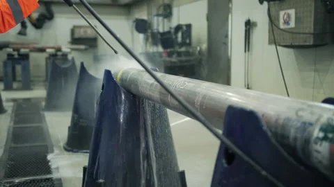 Worker using high pressure washer to clean oil drilling pipe Stock Footage 309327856