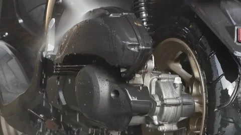 Worker using a hose for detailed cleaning. Spraying and washing a motorbike in Stock-Footage 197555306