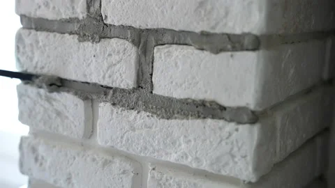 Worker using industrial spatula for grouting wall joints after filling with Stock Footage 226151937