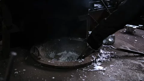 Worker using a ladle to pour molten metal at an industrial foundry for cast.. Vídeo Stock 333246580
