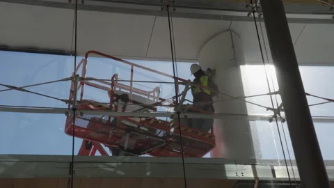 Worker Using Lift Platform for Column Maintenance in Modern Building 動画素材 313812236