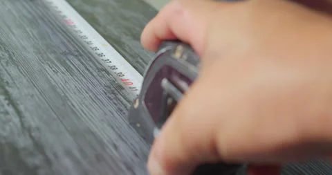 Worker using measuring tape on wooden surface Stock Footage 318299648