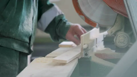 Worker using a miter saw  cuts plywood products. close-up. production. Stock Footage 231220723