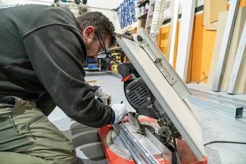 Worker using miter saw for metal profile cutting Stock Photos