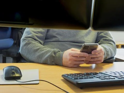 Worker using mobile phone in office and not being productive Stock Photos