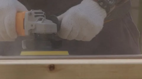 Worker Using Orange Electric Sander on Wooden Frame Edge Close-Up Stock Footage 336561648