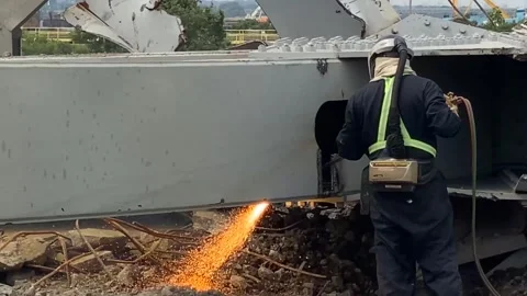 Worker using oxyacetylene torch to cut steel wreckage from Key Bridge Stock Footage 277192538