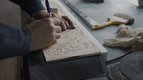 A worker using a pen, traces lines on lined paper, thereby applying a drawing th Stock Footage 99039313