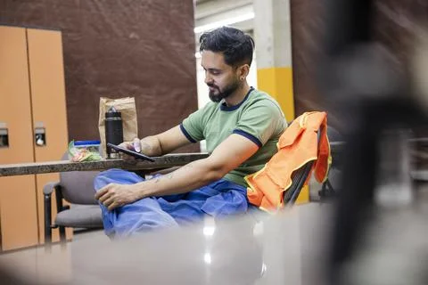Worker using phone at lunch break in locker room Stock Photos