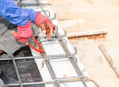 Worker using pliers for Bundle of steel rebar. Stock Photos