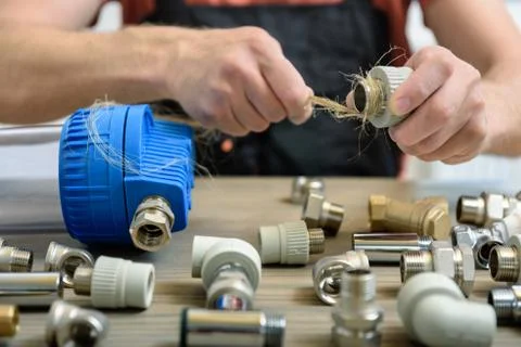 The worker is using a plumber's hemp fibers. Stock Photos