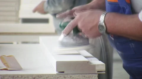 Worker using a power sander to smooth part of the doors frame. Stockbeeldmateriaal 57219756