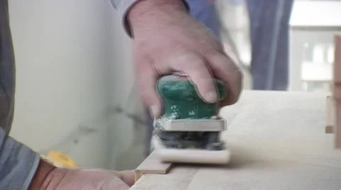 Worker using a power sander to smooth part of the doors frame. 库存影片 57219875