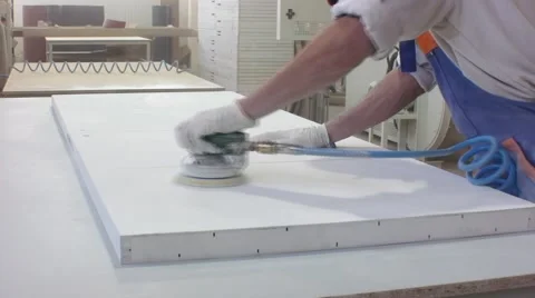 Worker using a power sander to smooth part of the doors frame. Video stock 57220025