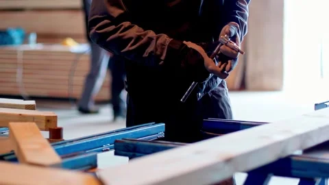 Worker using power tool on wooden frame in workshop for carpentry and Stock Footage 332233027