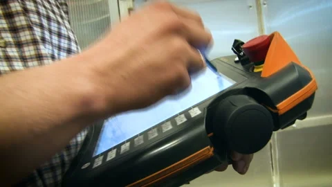 Worker using the remote control adjusts equipment using the stylus. Aircraft Stockbeeldmateriaal 108340728