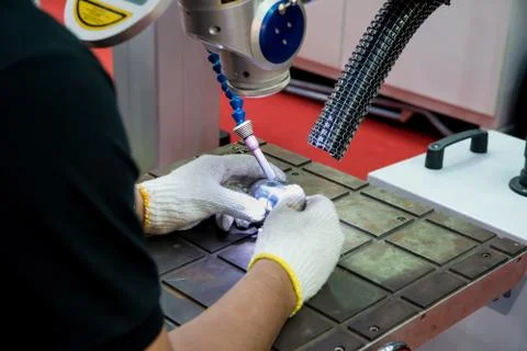 Worker using repair mold and die part by Laser welding machine in factory. Stock Photos
