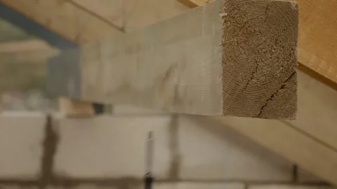 Worker using screw gun to secure nail in wooden beam during construction Stock Footage 324669728