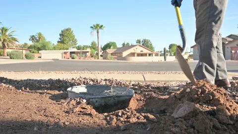 Worker using shovel to dig up an unground trashcan, common in Arizona Video stock 196865847