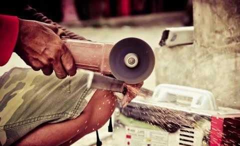 Worker using a small grinder for cutting metal Photos