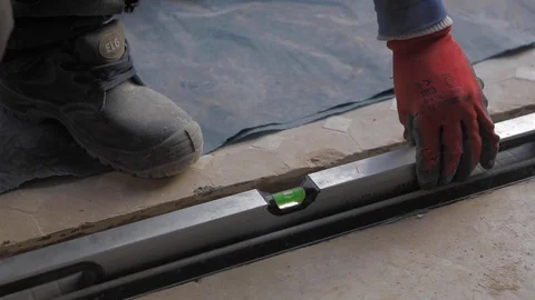 Worker using a spirit level to check if the floor is straight in building site. Vídeos de archivo 110771533