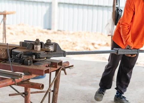 Worker using steel bending machine rebar. Foto stock
