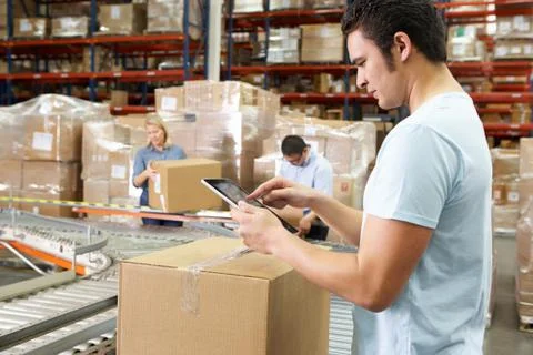 Worker using tablet computer in distribution warehouse Stock Photos