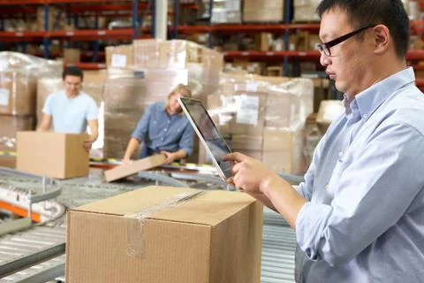 Worker using tablet computer in distribution warehouse Stock Photos