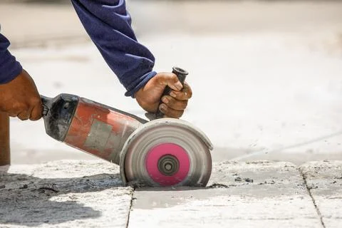 Worker using tool to cut concrete floor Stock Photos