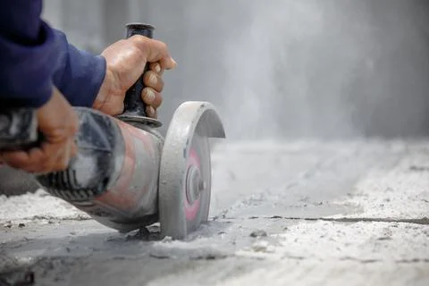 Worker using tool to cut concrete floor Stock Photos