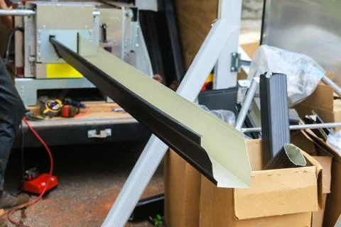 Worker using tools to fabrication aluminum gutter channels while materials Stock Photos