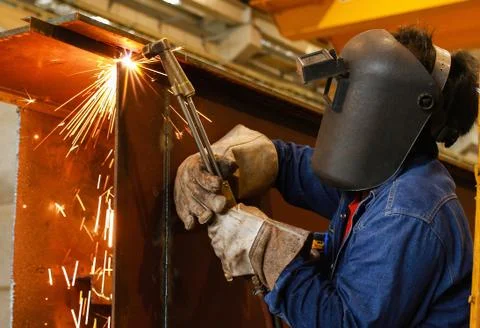 Worker using torch cutter to cut through metal Stock Photos