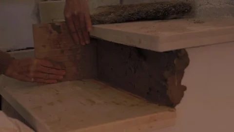 Worker using a trowel to apply brown cement mixture, made with sand, gravel and 動画素材 110771466
