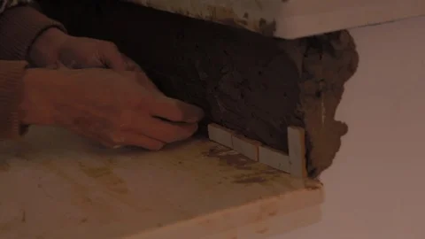 Worker using a trowel to apply brown cement mixture, made with sand, gravel and Video stock 110771470