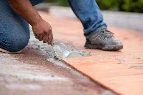 Worker Using Trowel to Apply Cement for Next Roof Tile Stock Photos