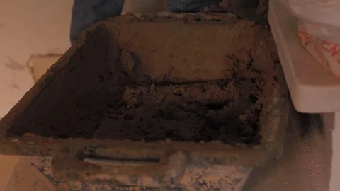 Worker using a trowel to take brown cement mixture made with sand, gravel and 動画素材 110771460
