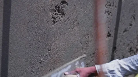 Worker using trowel tool and wooden float tool for wall plastering at Stock Footage 331230443