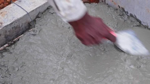 Worker using Trowel tool for leveling concrete mixer on lower tank slab work at Stock Footage 328715164