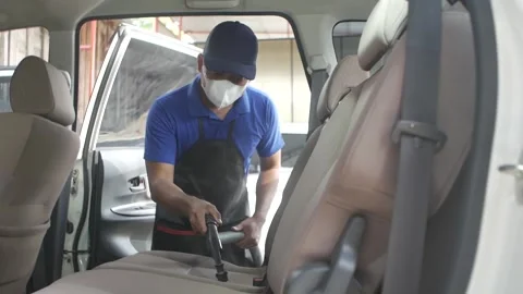 Worker using vacuum cleaner in the car. Man vacuuming vehicle's interior in Video stock 197555234