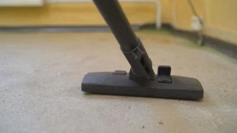 A worker using a vacuum cleaner removes construction debris. A worker is clea Stock Photos