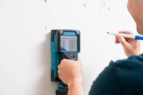Worker Using Wall Scanner and Marking Stud Location Foto stock