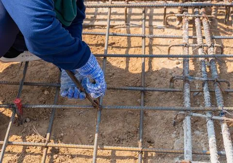 Worker using wire and pliers to tie the rebar. Foto stock