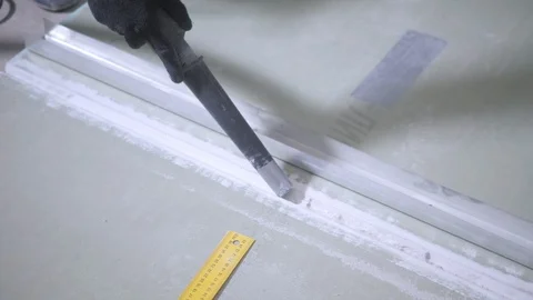 Worker vacuums plasterboard panel groove with dustbuster Stock-Footage 108582946