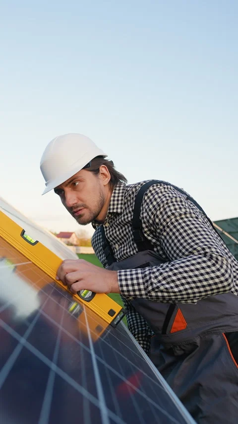 Worker Verifies Solar Panel Installation with Precision Tool Stock Footage 296852085
