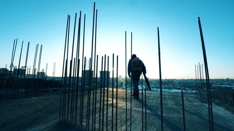 Worker is walking along the open construction site with a hammer. Construction Vídeos de archivo 128303935