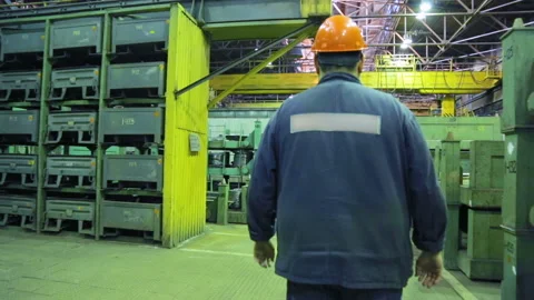 Worker walking along a walkway in a machine works Stockbeeldmateriaal 100333954
