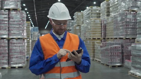 Worker walking inside of the factory storehouse with a checklist in his hands Stock Footage 278184956