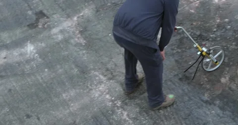 A worker is walking with the measuring wheel, measure the road Video stock 247627759